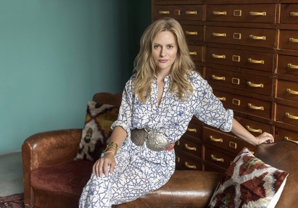 Photo showing Aimee Mullins sitting on the arm of a leather chair